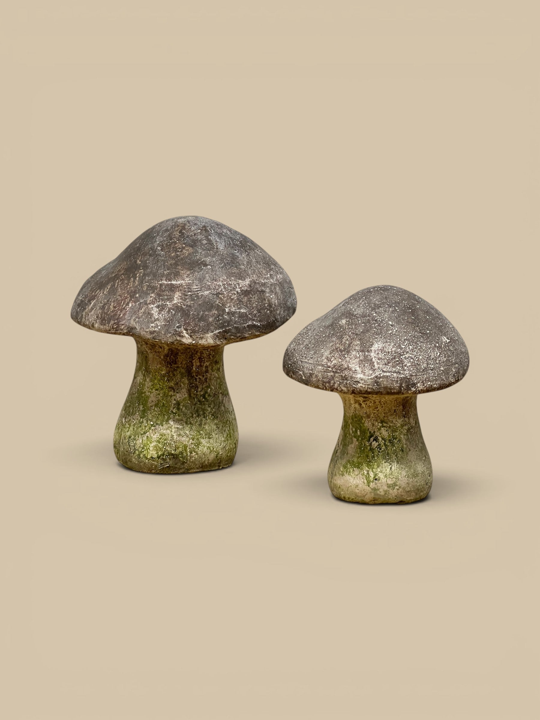 Homestyle Collective weathered garden mushroom statues with moss-terracotta finish, available in two sizes.