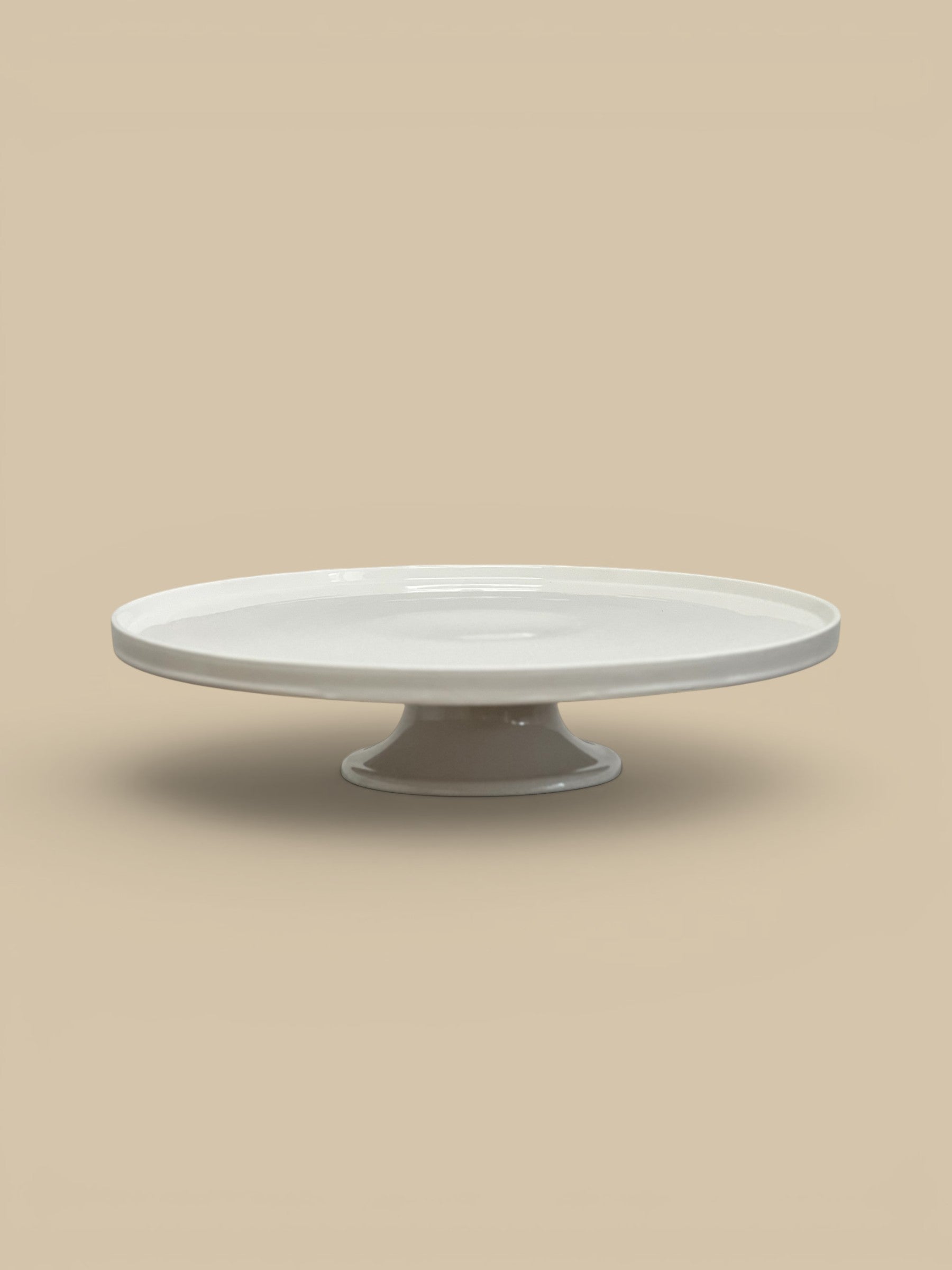 Homestyle Collective white stoneware pedestal cake stand with a glossy finish and classic round lipped silhouette, 18" round.