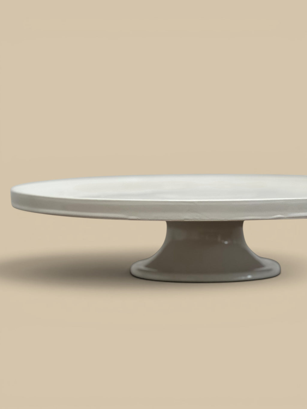 Homestyle Collective white stoneware pedestal cake stand with a glossy finish and classic round lipped silhouette.