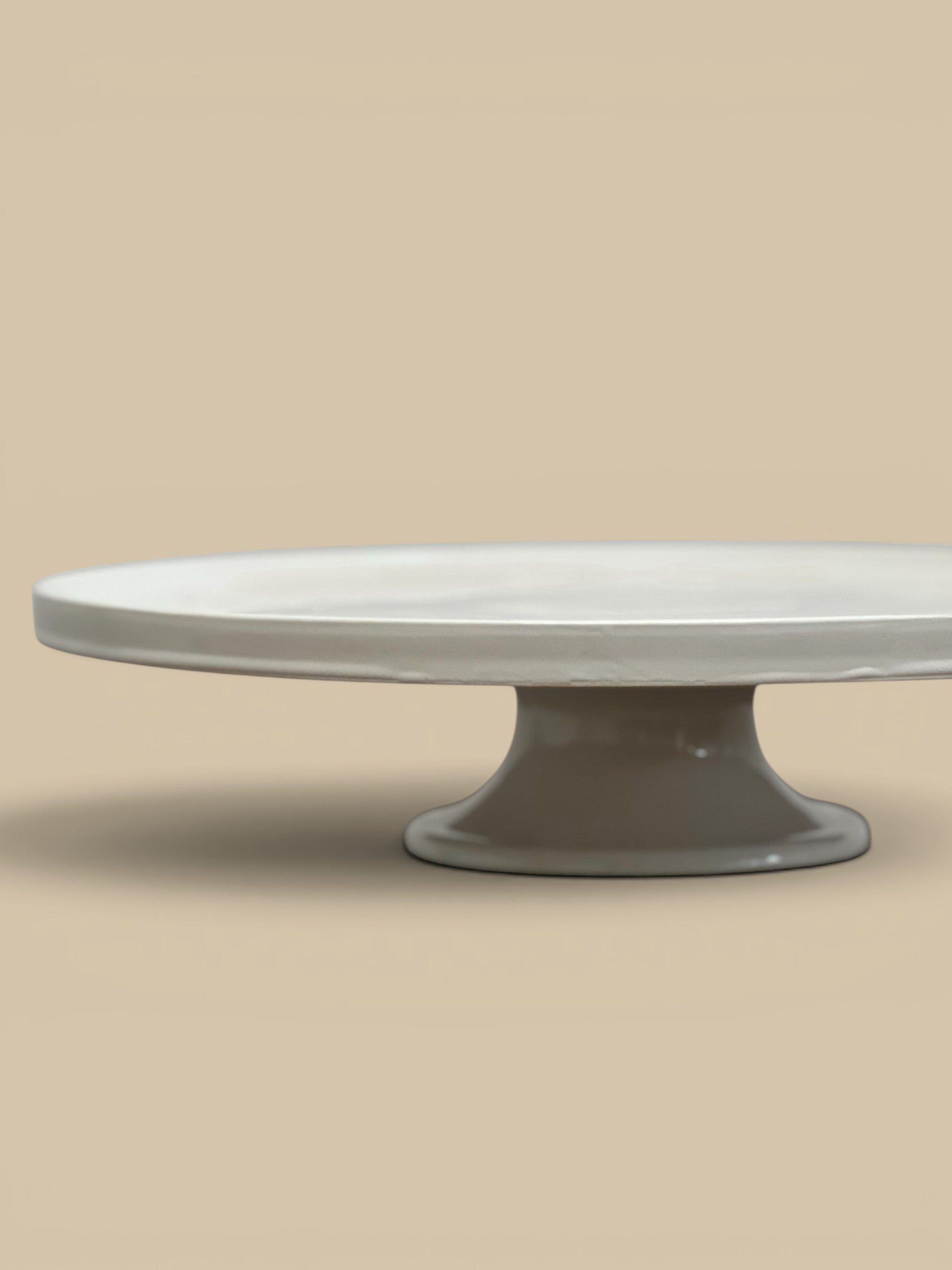 Homestyle Collective white stoneware pedestal cake stand with a glossy finish and classic round lipped silhouette.