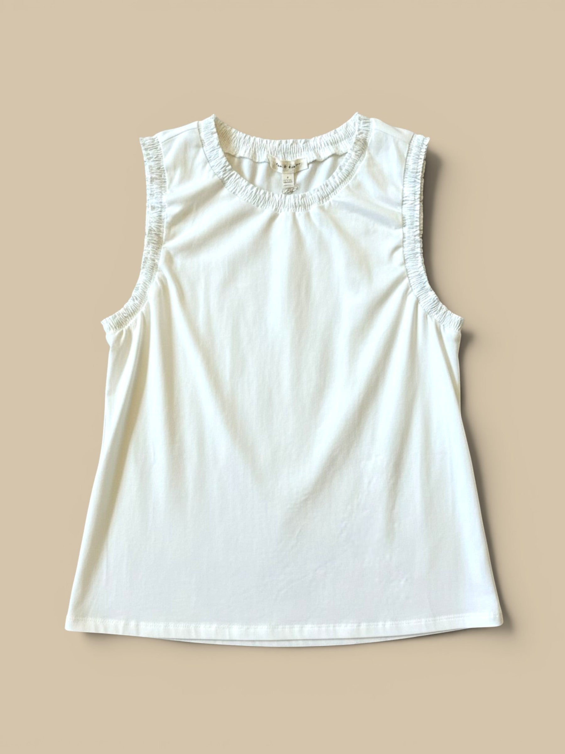 Homestyle Collective white cotton jersey sleeveless top with ruffled neckline and armholes.