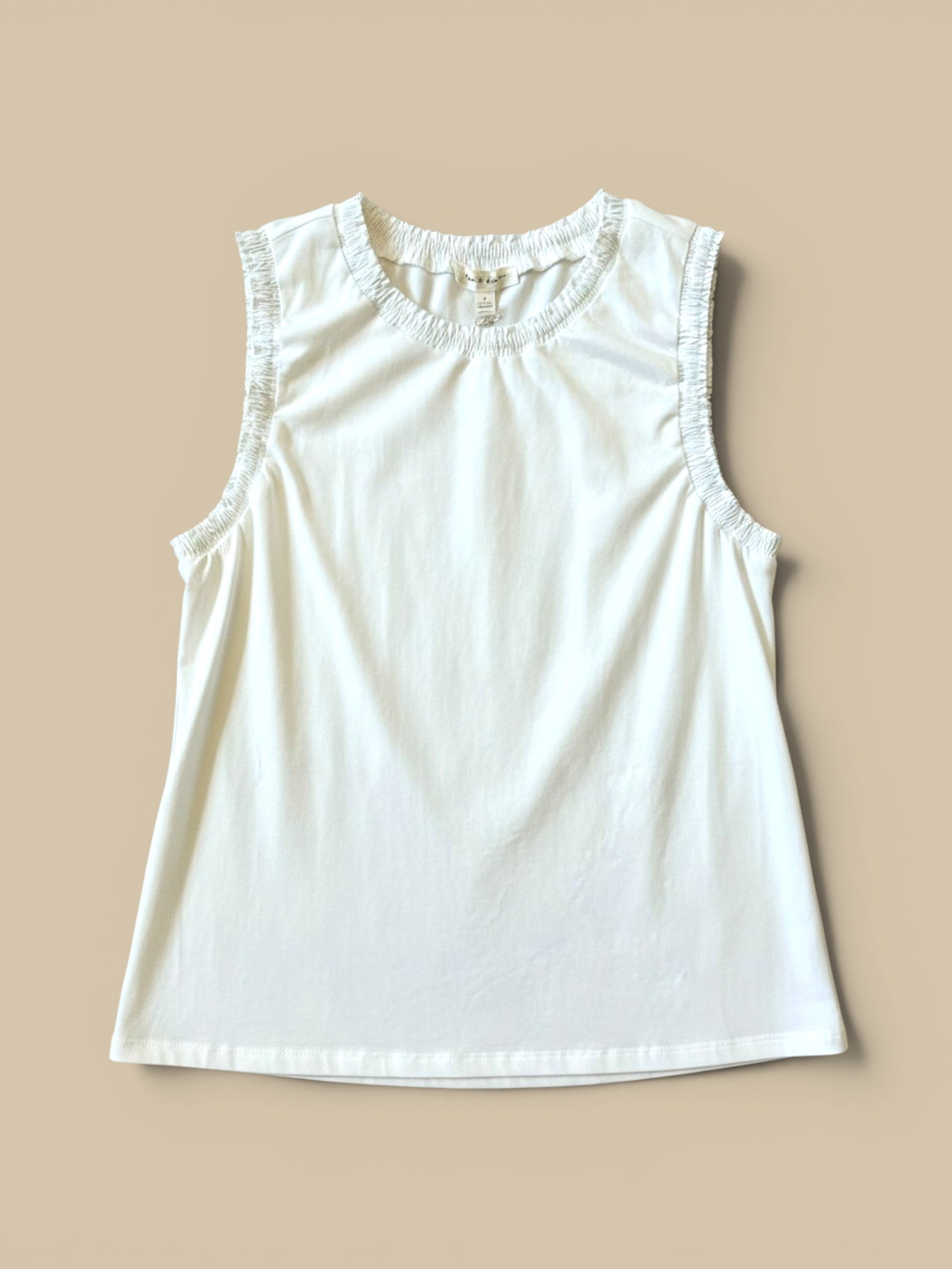 Homestyle Collective white cotton jersey sleeveless top with ruffled neckline and armholes.