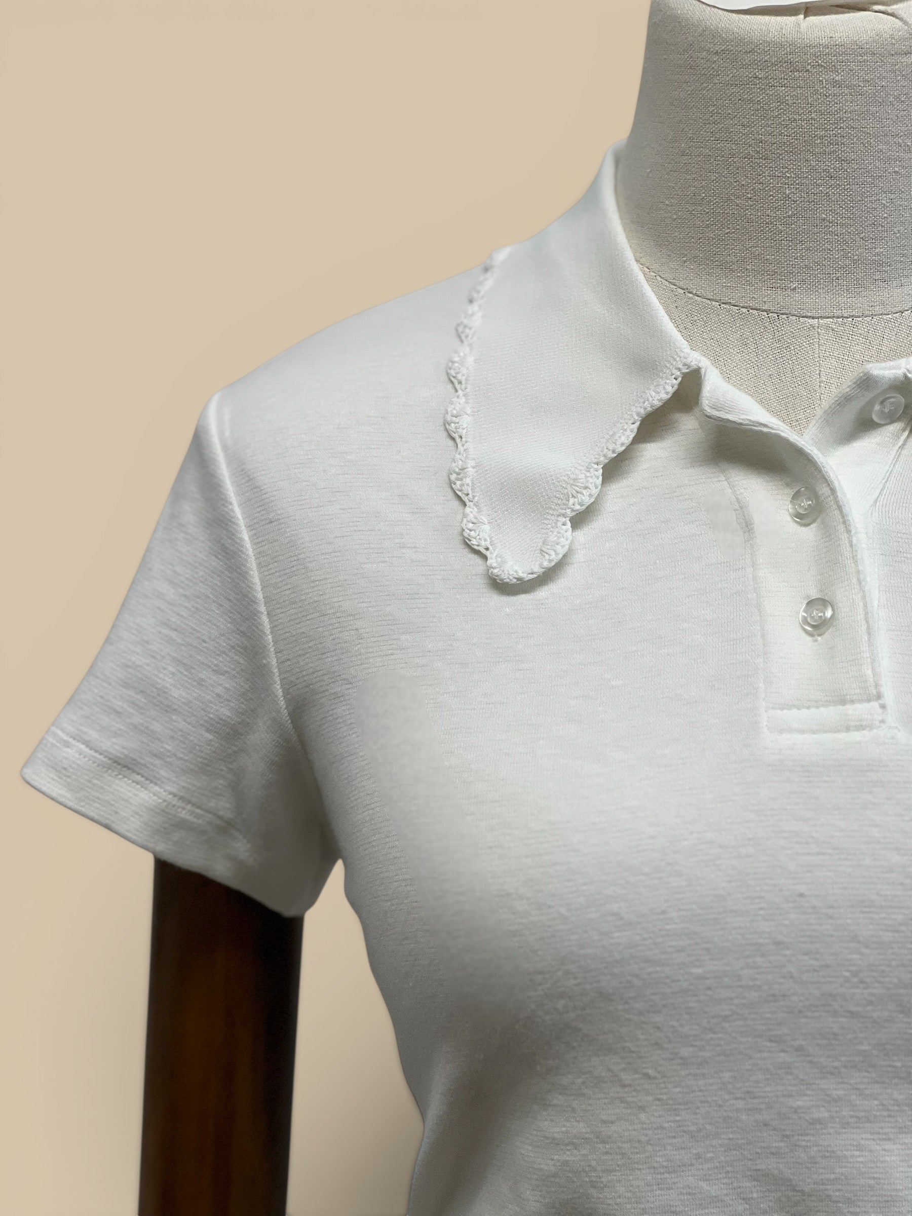 Homestyle Collective white knit polo shirt with short sleeves and a scalloped edge collar.
