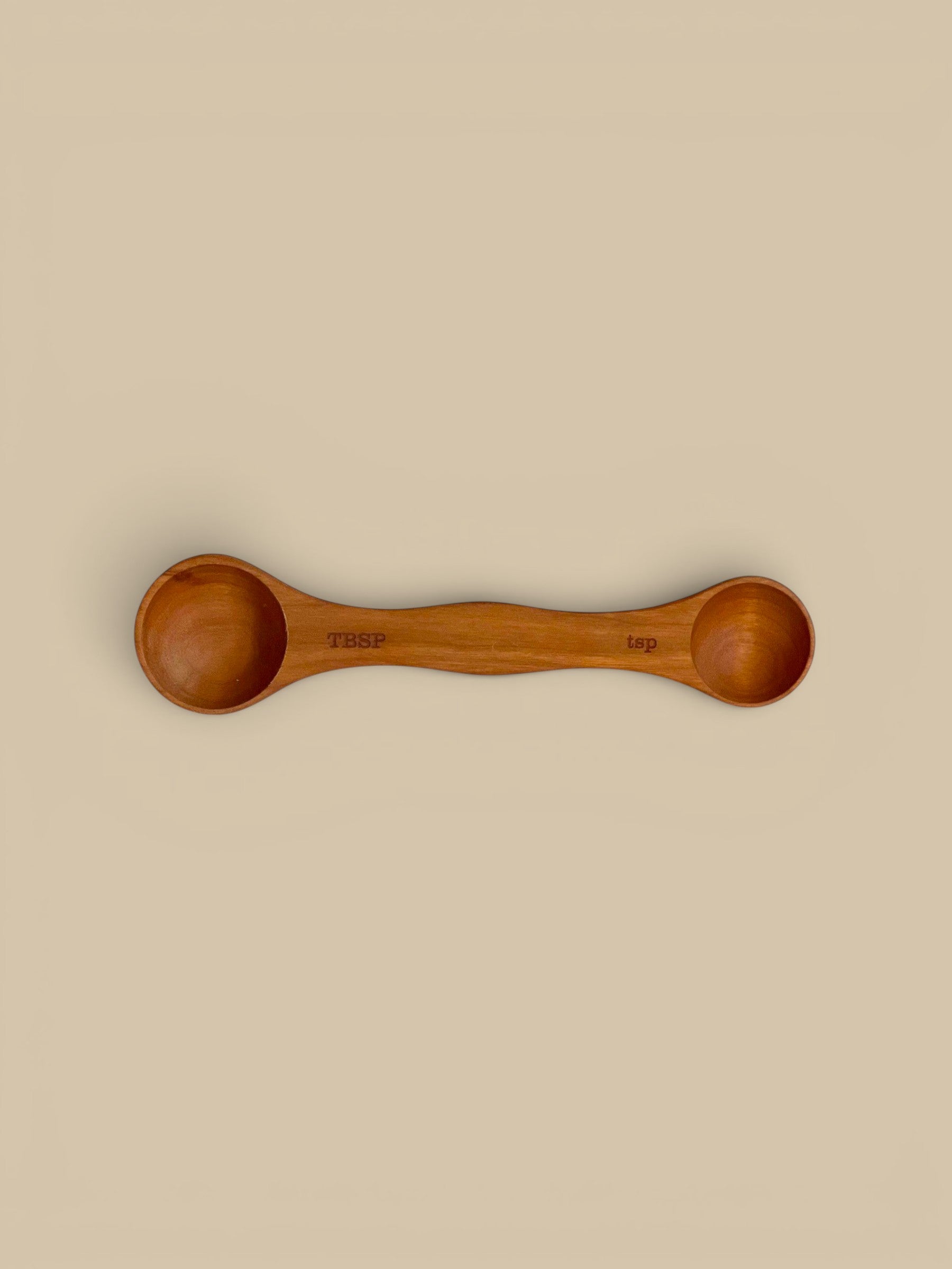 Homestyle Collective wooden measuring spoons in light, medium, and dark wood finishes. Each double-ended spoon measures tablespoon and teaspoon.