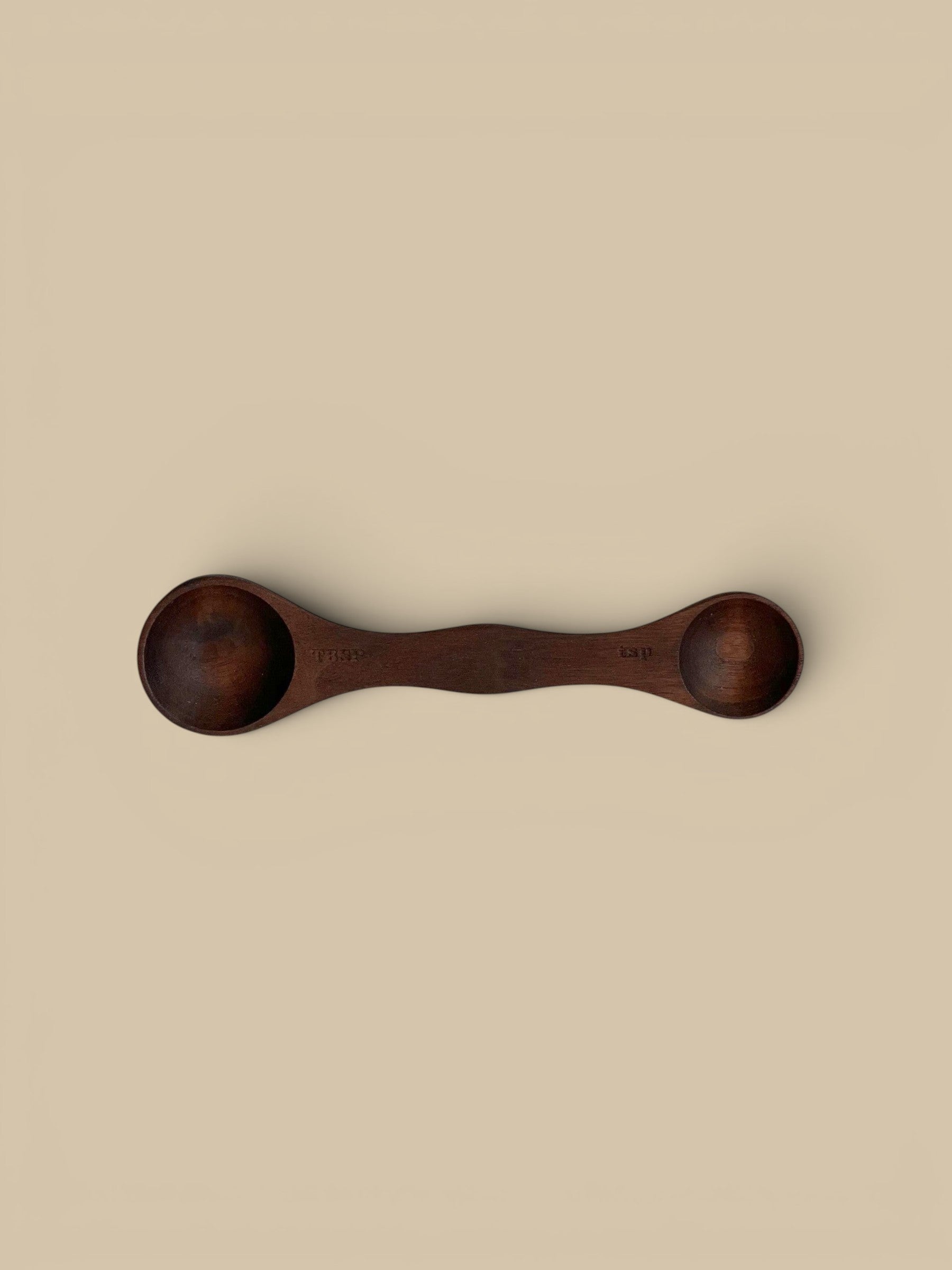 Homestyle Collective wooden measuring spoons in light, medium, and dark wood finishes. Each double-ended spoon has tablespoon and teaspoon measurements.