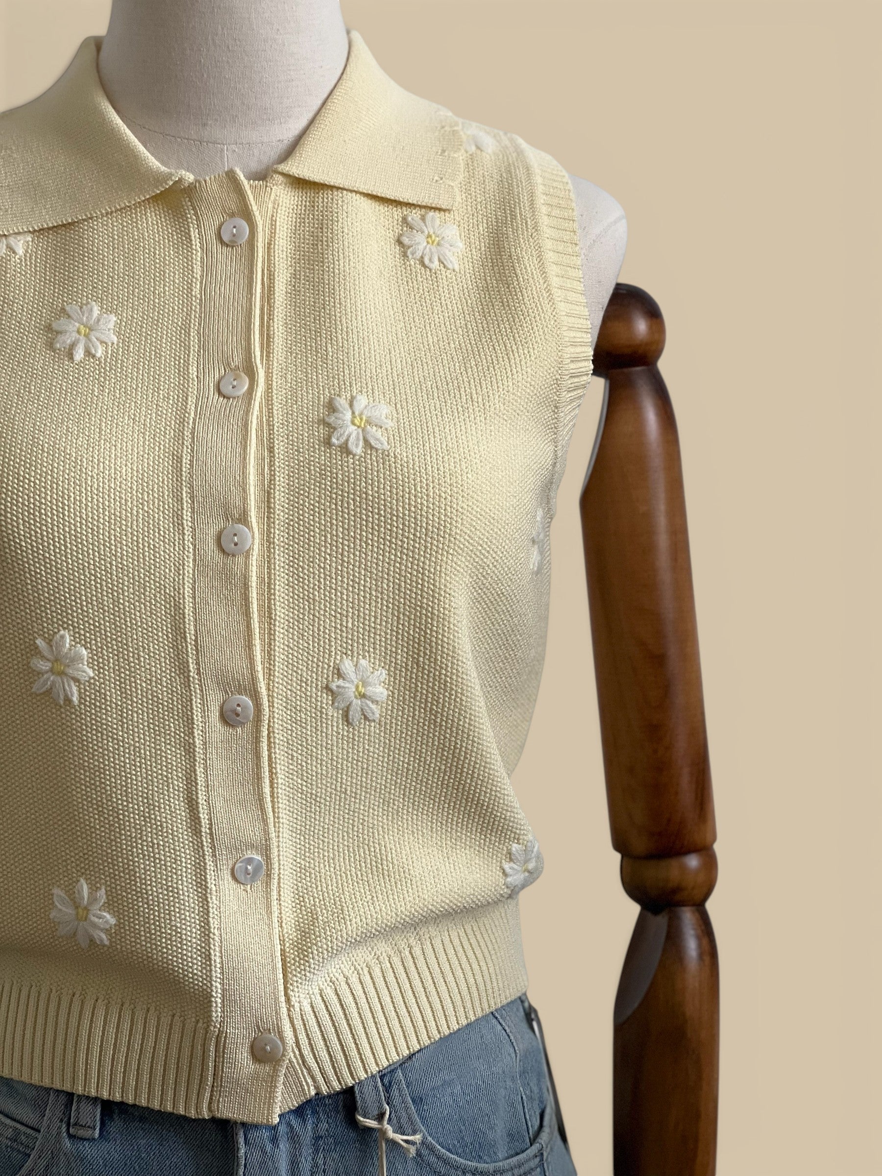 Homestyle Collective butter yellow knit sleeveless top with embroidered white daisies and a collared neckline.